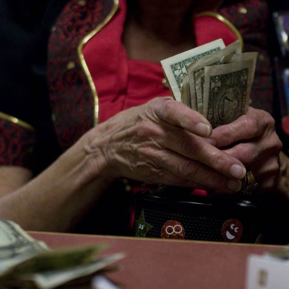 Close up of a woman's hands counting out $1 bills