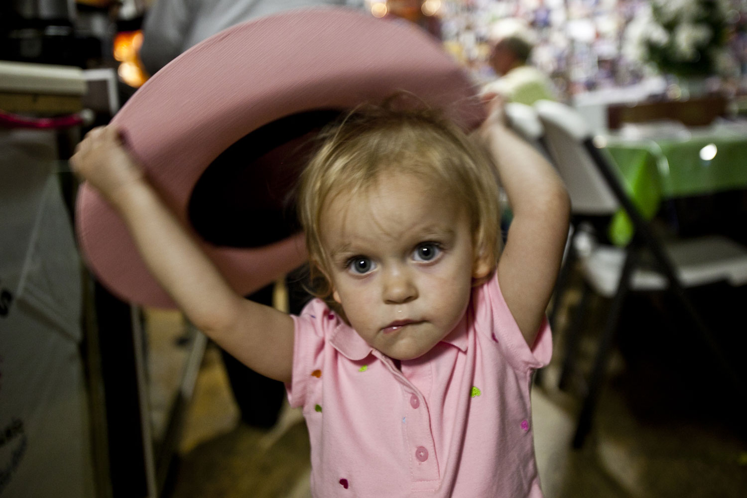 A young girl with a pink hat bites her lip