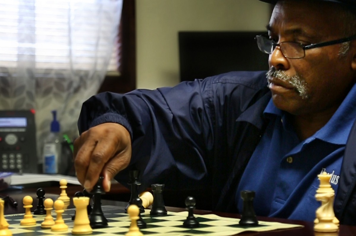 Rev. Reggie Longcrier playing his daily morning game of chess in his office at Exodus Homes.