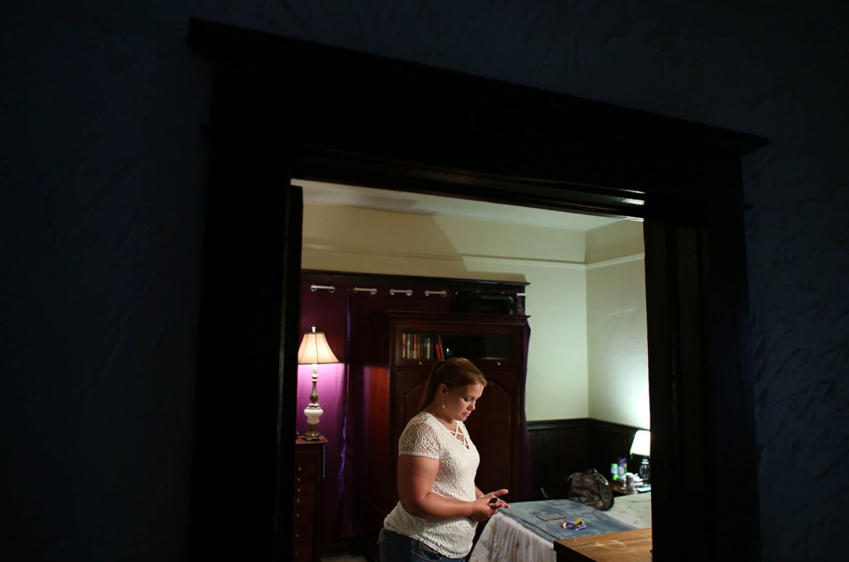 After being drug free for two years Catie Brown quietly stands in her bedroom holding her multiyear Narcotics Anonymous Chip.