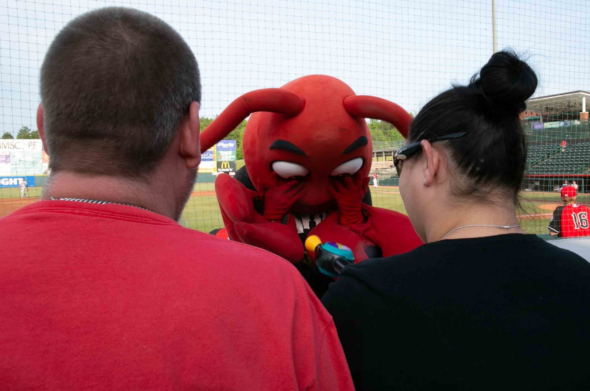 Two fans play Bop-It with Conrad the Crawdad at the baseball game on the L. P. Frans Stadium on May 15th, 2018.