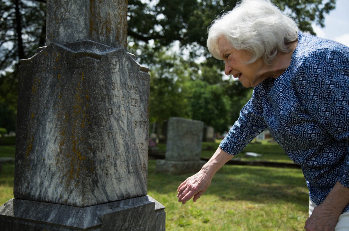 Mainess studies the headstone of a notable Hickory resident she has researched.
