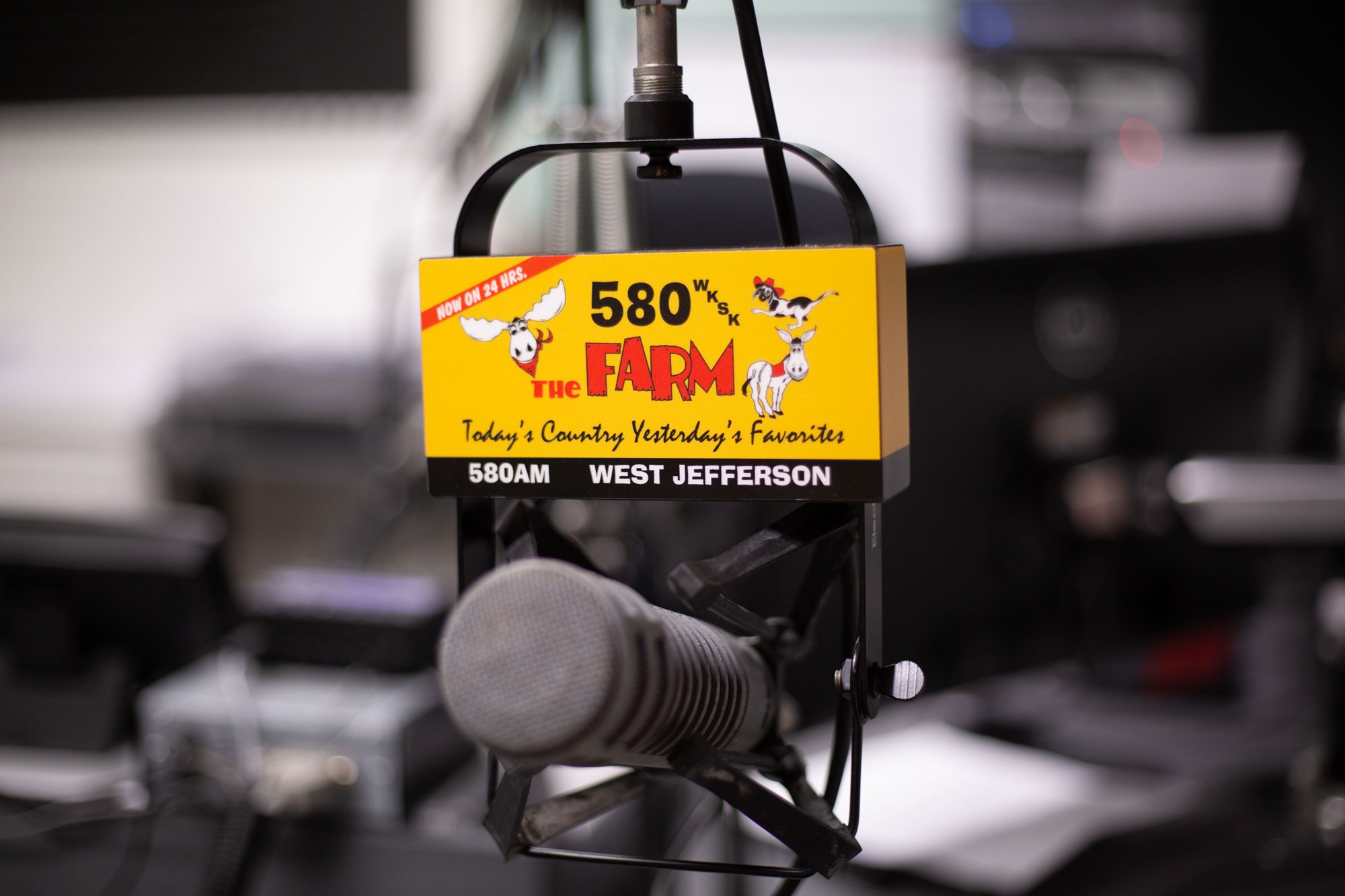 A microphone has a logo for a radio station called "The Farm" with a yellow background and moose cartoons