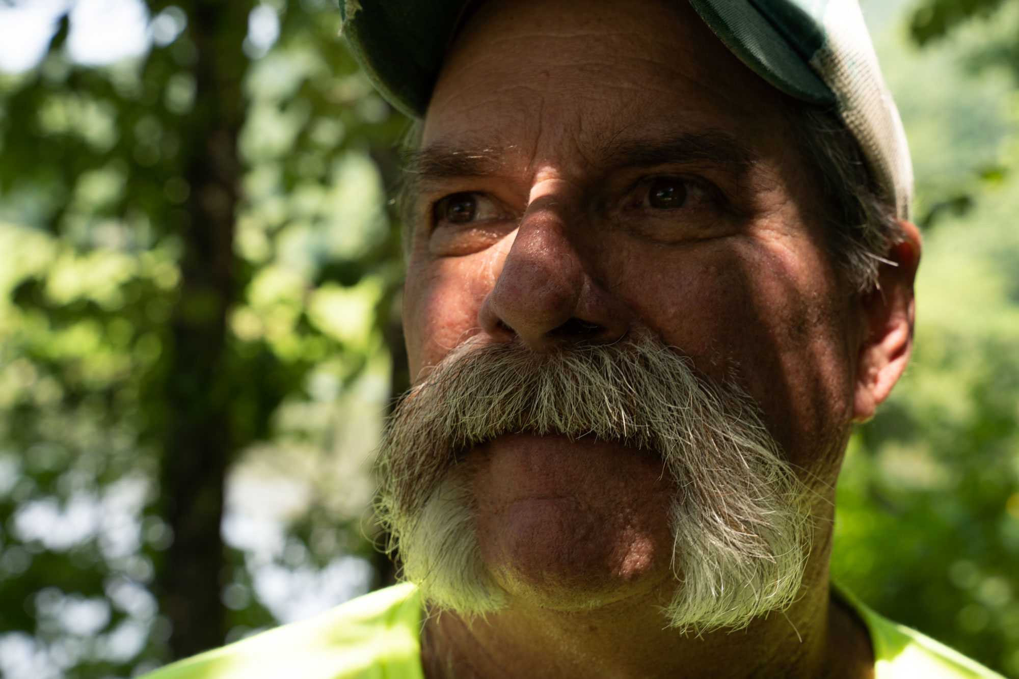 A man with a large mustache looks into the distance.
