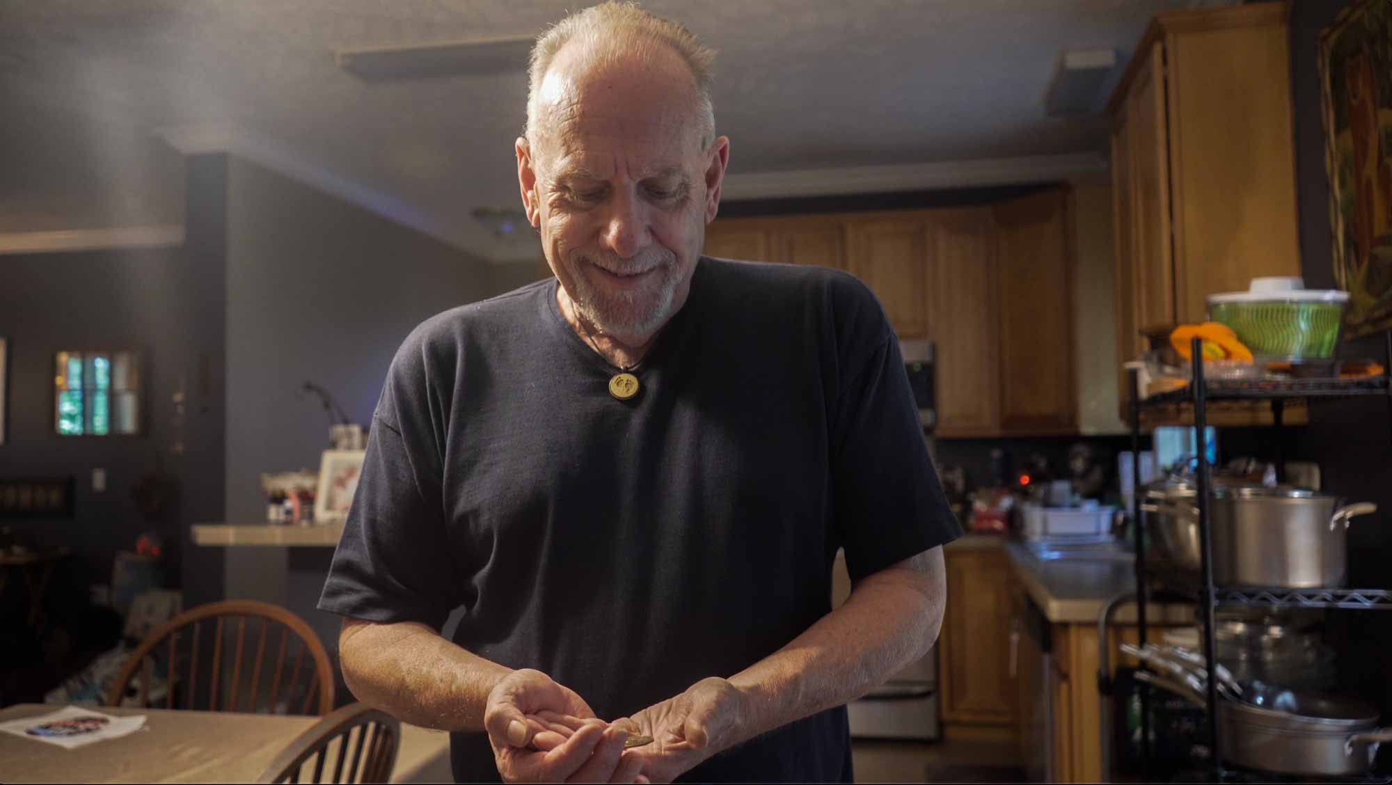 Man cupping his hands as he holds a chip in his kitchen