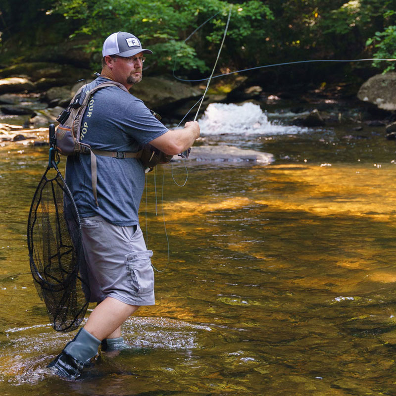 Man casting a fishing line in a river