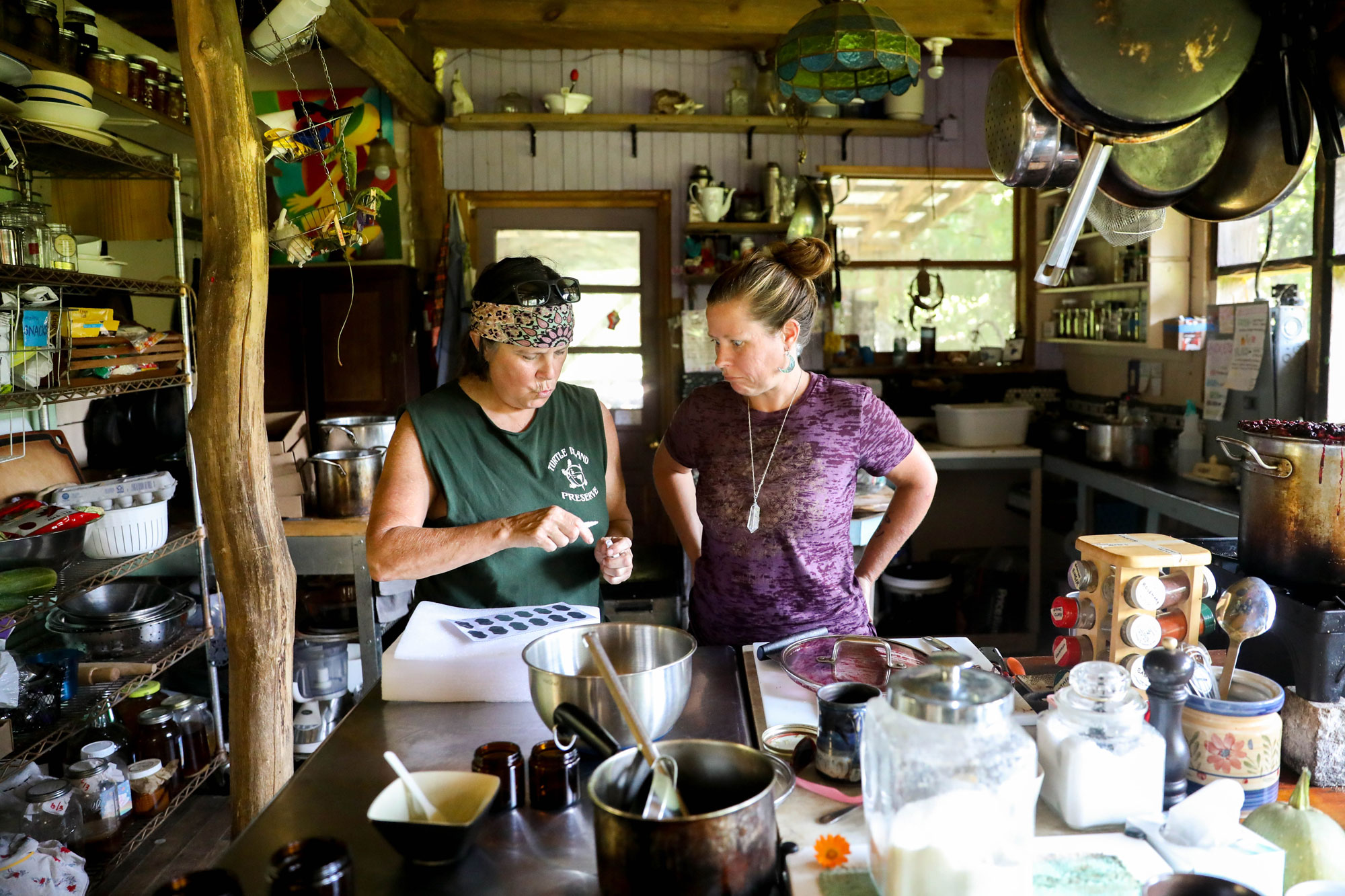 Two women stand in a kitchen over a bowl