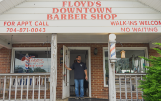 man in front of his barber shop