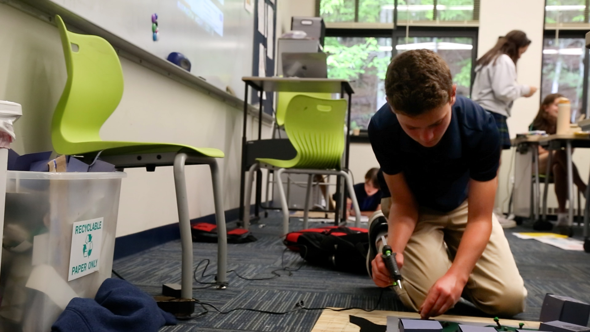 Students at the Carolina Day School had the opportunity to create proposals for a piece of land destroyed by Hurricane Helene in the River Arts District. Michael Quast glues a clay tree to his final project model which is due at the end of the week.