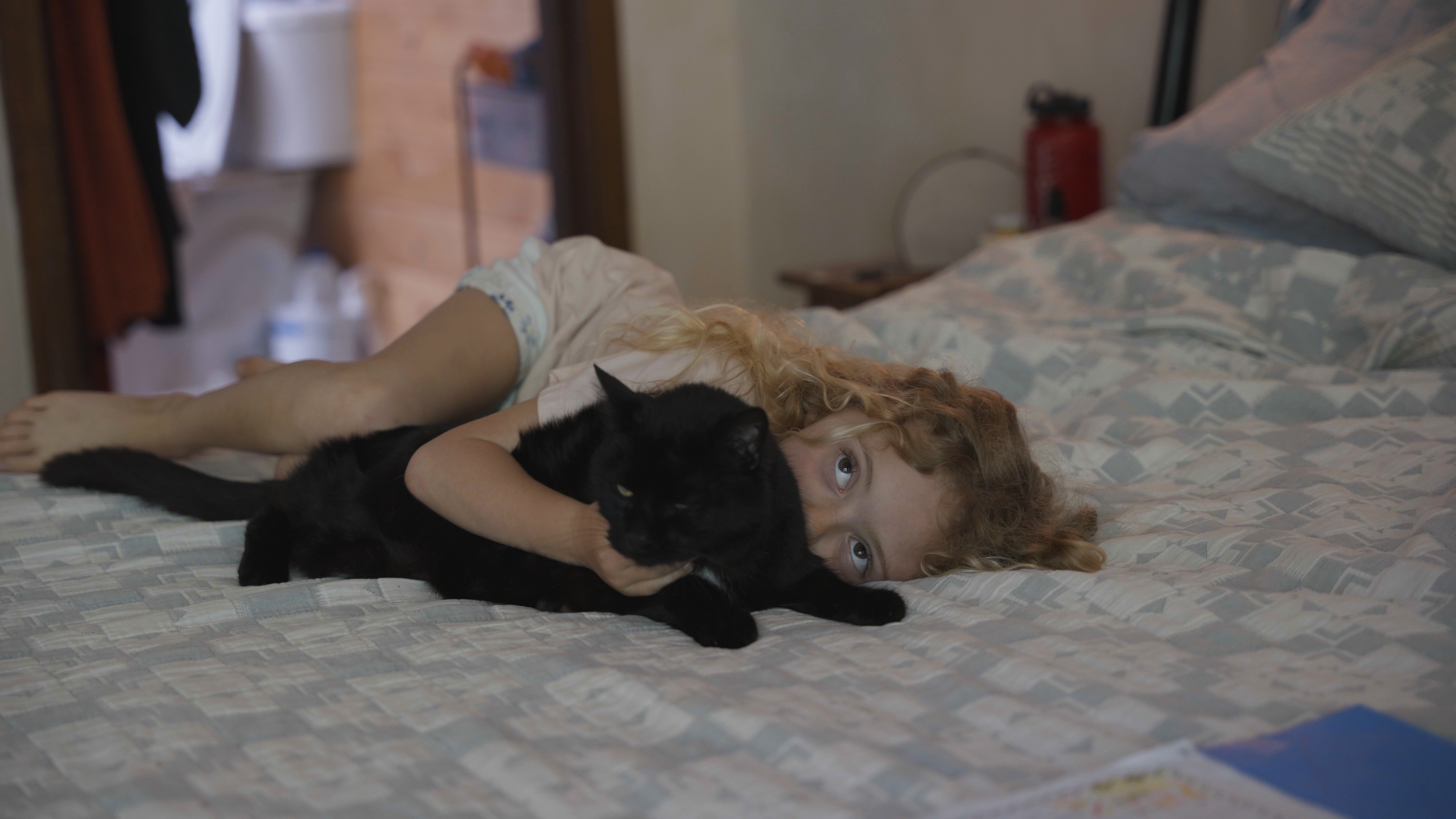 Baylen’s 7-year-old daughter holds the family’s cat on Baylen’s bed in their home. “I’m feeling more and more hopeful for the future,” Baylen said. “I’m feeling more and more solid every day.”